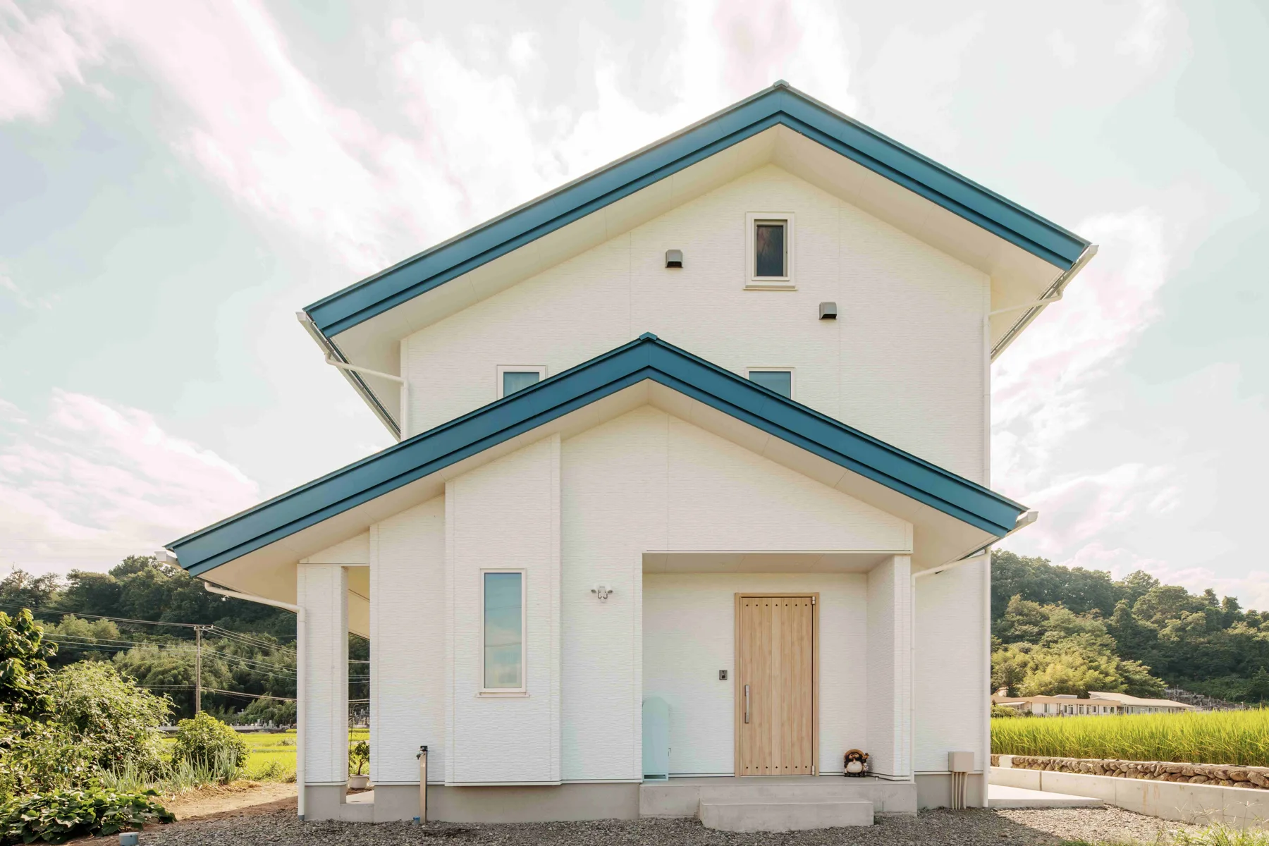 白い外壁と青い屋根の外観